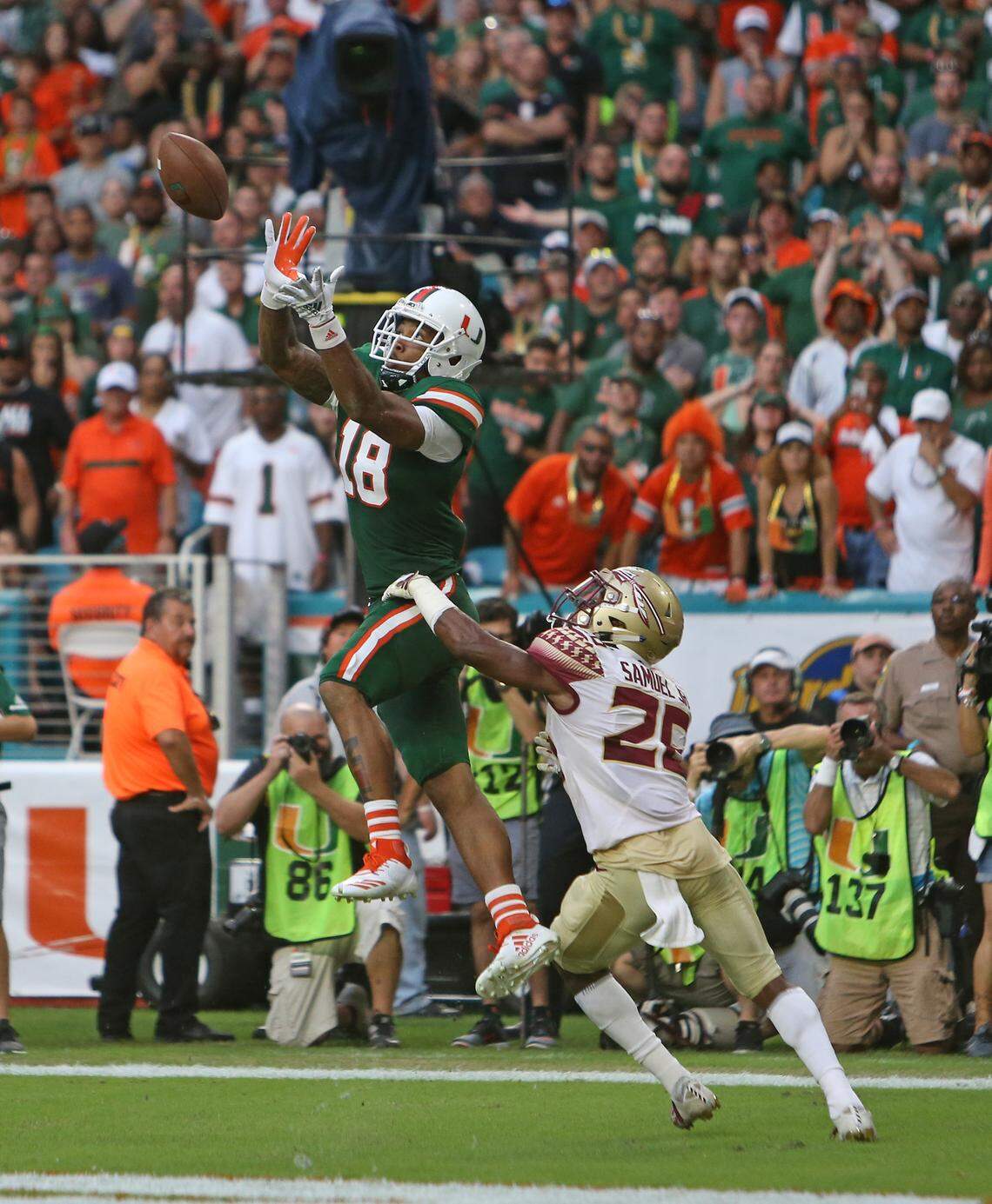 Miami Hurricanes wide receiver Lawrence Cager (18) scores a touchdown against Florida State Seminoles defensive back Asante Samuel Jr. in the third quarter Saturday, Oct. 6, 2018, at Hard Rock Stadium in Miami Gardens.