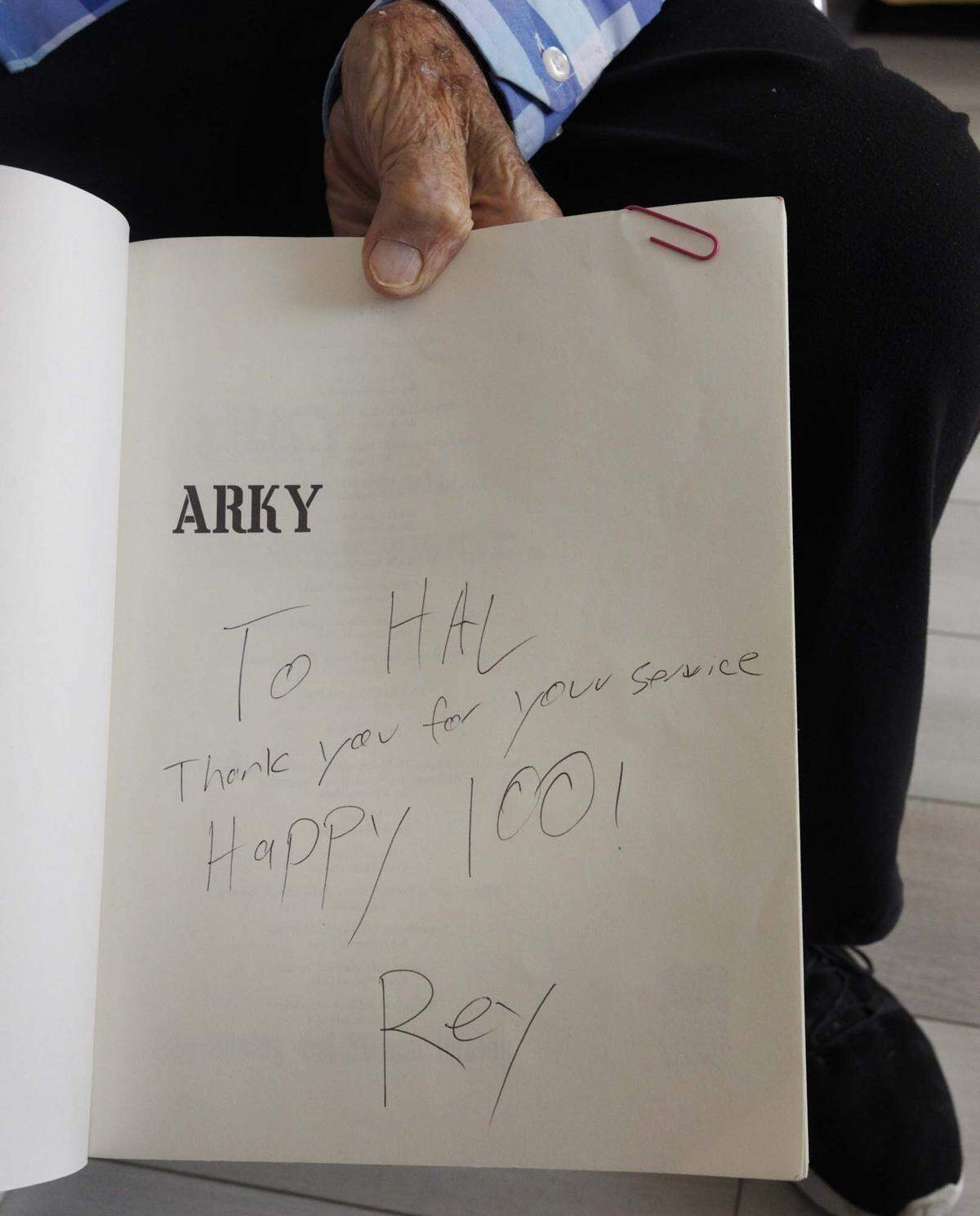 Hal Silberman, who is turning 101 on May 1st, shows a book he got forms birthday the previous year about the USS Arkansas he was stationed on in WWII on Thursday, April 30, 2026, at the Palace retirement community in Coral Gables, Fla. Silberman is one of the oldest WWII veterans in South Florida. He stays active in his retirement community, plays chess, and because he is a former doctor, gives lectures.