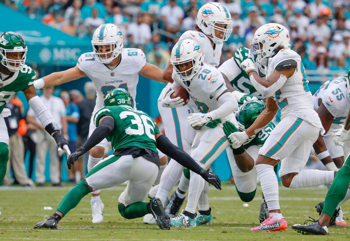 Miami Dolphins running back De’Von Achane (28) on a carry against the New York Jets in the first half of their NFL football game at the Hard Rock Stadium in Miami Gardens, Florida on Sunday, December 8, 2024.