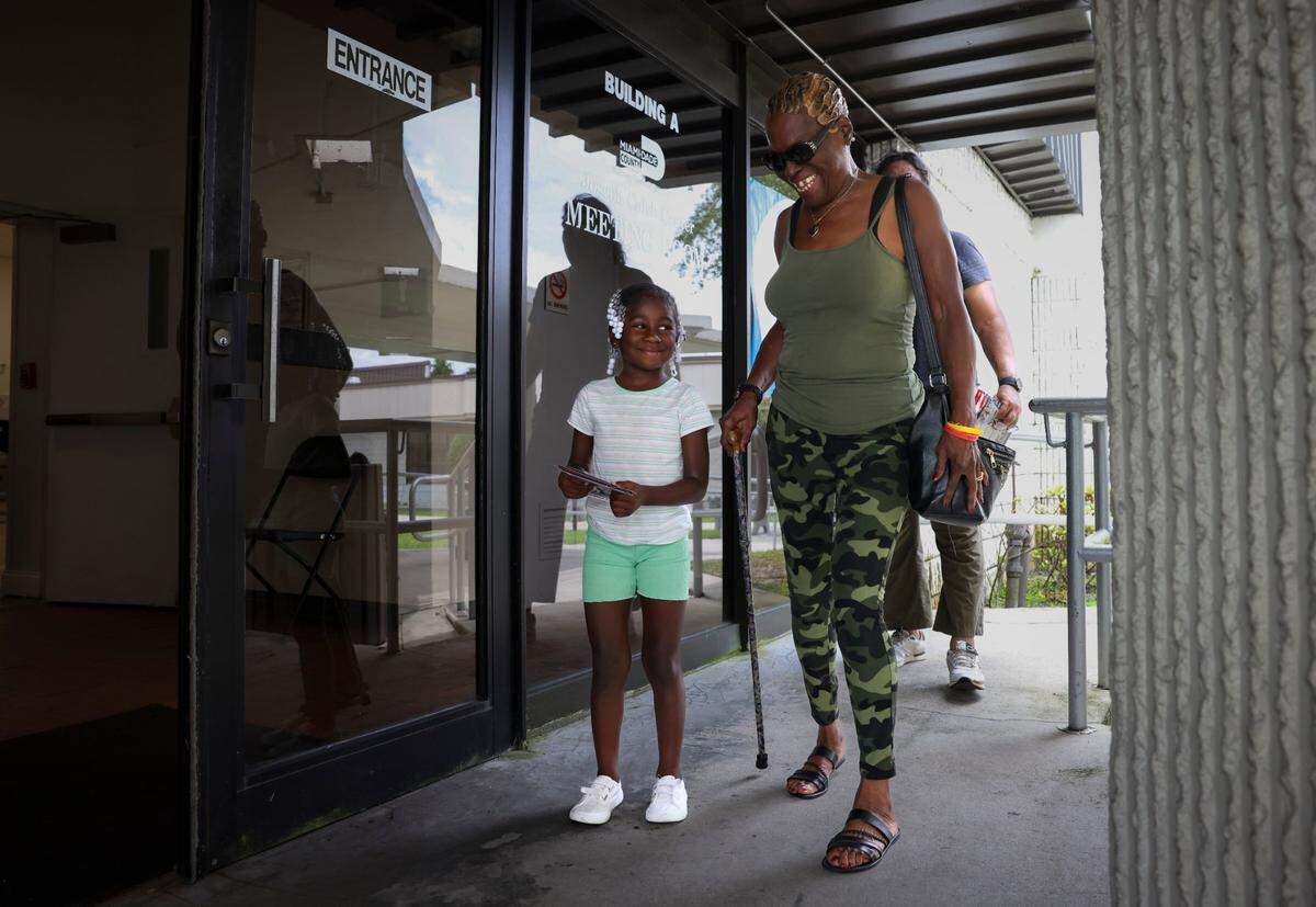 Mae Brown, right, looks down at her great granddaughter Tyliah Davis, left, as she walks in to vote after church during the last day of Early Voting on Sunday, Aug. 18, 2024, at the Jospeh Caleb Center in Miami. Brown was a poll deputy for 12 years, but recently had hip surgery and couldn’t volunteer this year. The poll worker said that this has been their busiest day of early voting.