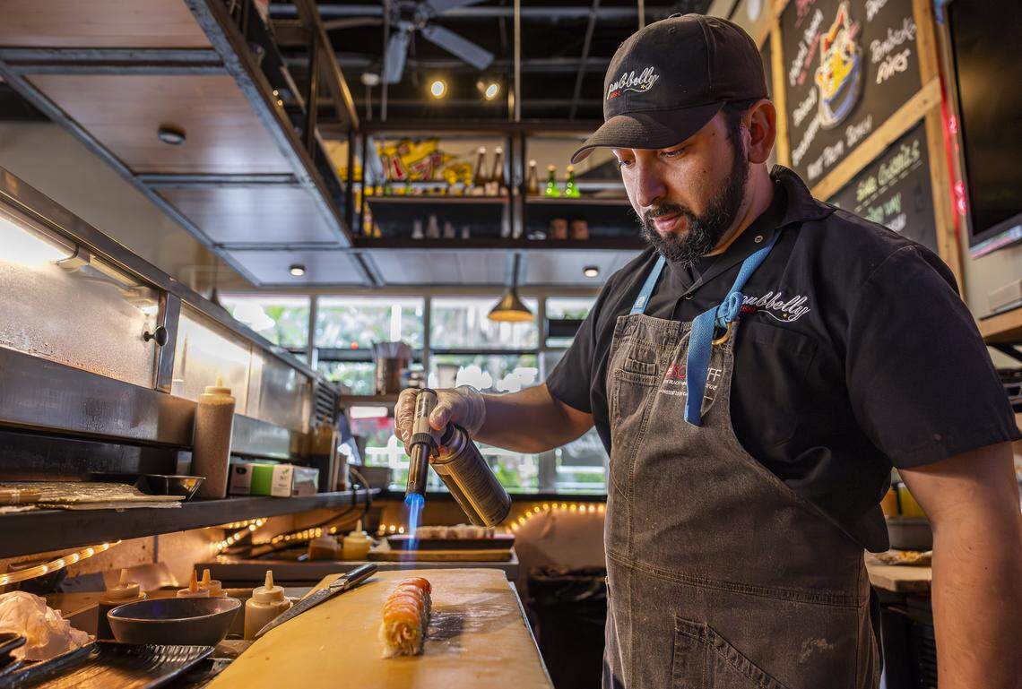Chef Pedro Barahona prepares a Sake Aburi Roll at Pubbelly Sushi on Thursday, Sept. 18, 2025, in Miami Beach, Fla. Pubbelly Sushi is celebrating its 15th anniversary. The roll consists of kanikama, seared salmon, yuzu miso, truffle oil and shichimi.