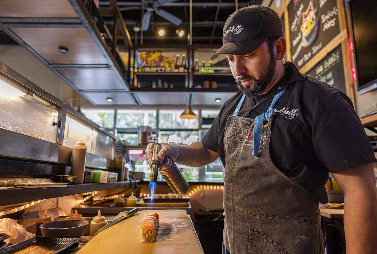 Chef Pedro Barahona prepares a Sake Aburi Roll at Pubbelly Sushi on Thursday, Sept. 18, 2025, in Miami Beach, Fla. Pubbelly Sushi is celebrating its 15th anniversary. The roll consists of kanikama, seared salmon, yuzu miso, truffle oil and shichimi.