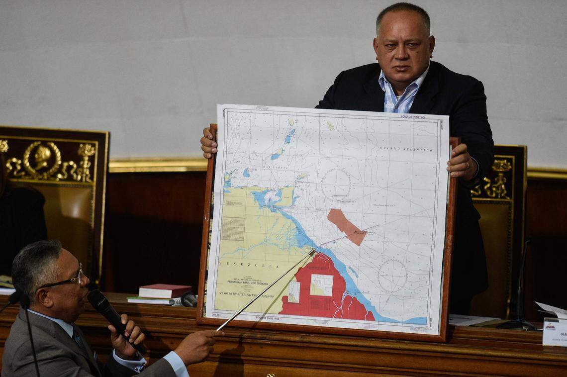 In January 2019, National Constituent Assembly member Pedro Careno, left, delivers a speech while Venezuelan deputy Diosdado Cabello holds a map showing the border between Venezuela and Guyana, during a session in Caracas. Guyana has called for the immediate release of the crew of two fishing vessels seized by Venezuela less than a month after the latter unilaterally extended its maritime boundary.