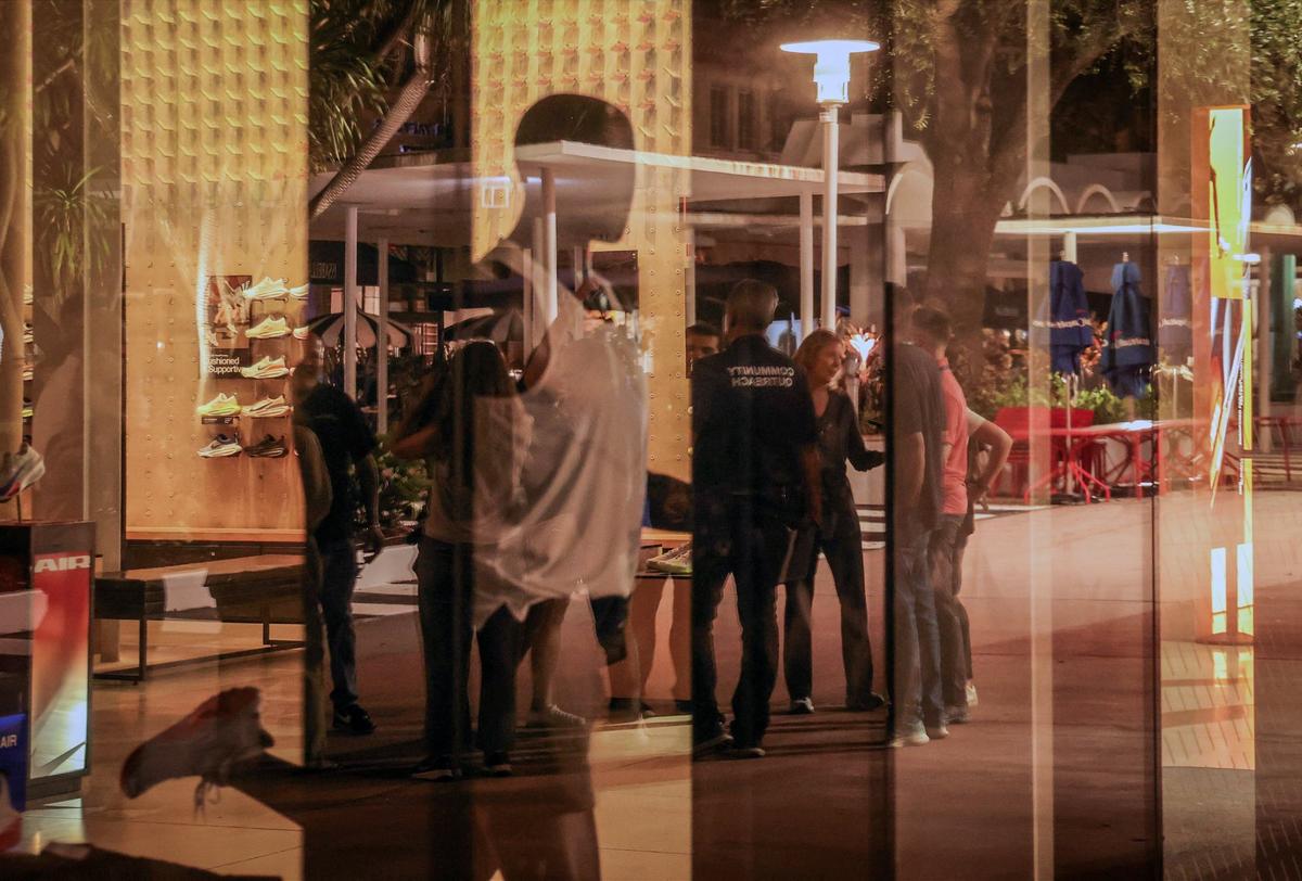 The canvassing team’s reflections are cast off a storefront window on Lincoln Road as they stop to regroup before continuing the count of the homeless unsheltered population on Thursday, Aug. 22, 2024, in Miami Beach, Florida.