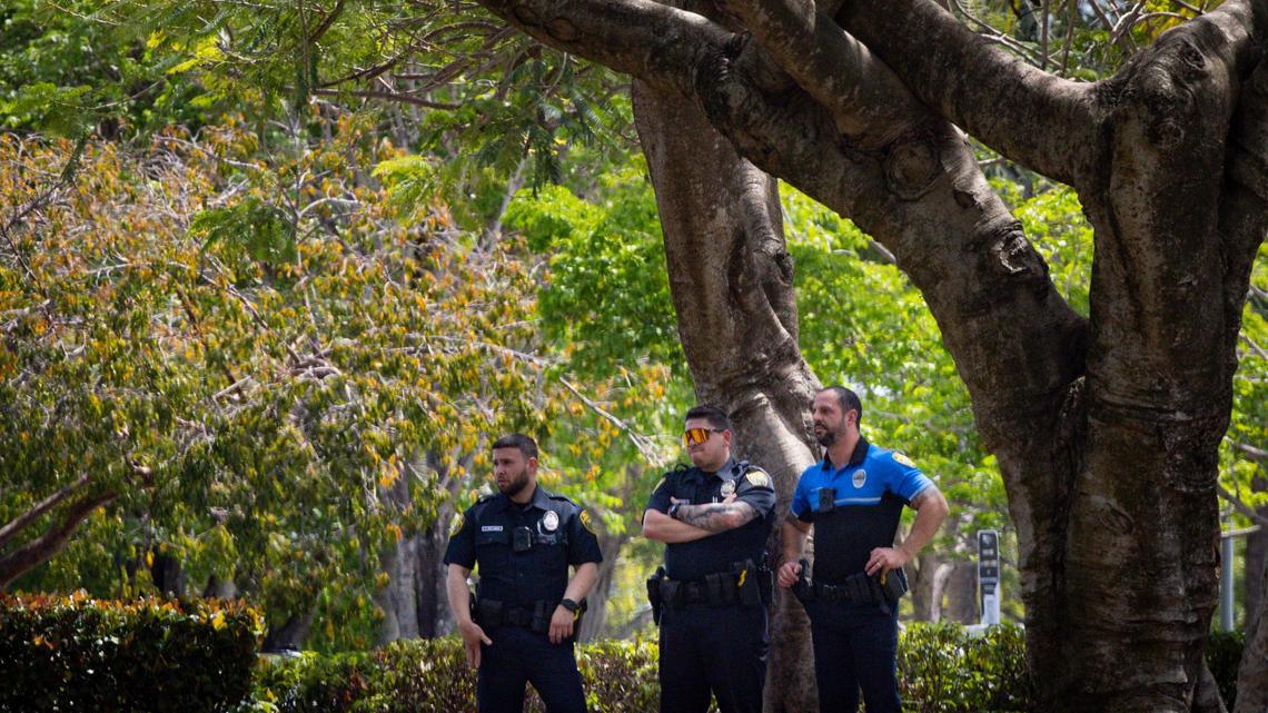 Police officers watch from across lawn during a gathering hosted by FIU students about Mahmoud Khalil, the Columbia student who faces deportation over his pro-Palestinian activism, on Wednesday, March 26, 2025, outside the Florida International University Ernest R.Graham Center in Miami, Fla.