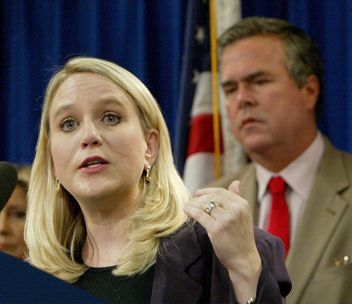 In September 2004, Tiffany Carr, head of the Florida Coalition Against Domestic Violence, spoke at a news conference held by then-Gov. Jeb Bush, right, to announce a public awareness campaign aimed at preventing disaster-related domestic violence. Bush’s wife, Columba, served on the coalition’s foundation arm for eight years.