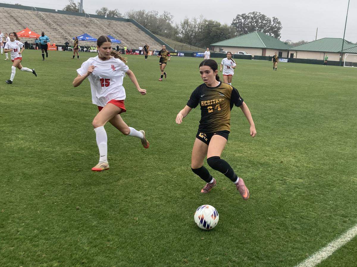 American Heritage midfielder Mae Collins outraces Bishop Kenny’s Josie Kapadia down the line to a 50-50 ball during Saturday’s Class 4A state championship game at Spec Martin Stadium in DeLand, Fla.