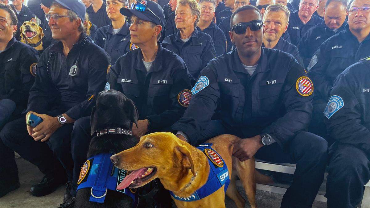 Oliver Samy sits with his dog, Lexie, during a send-off ceremony of the search-and-rescue team they’re both part of with the Miami-Dade County Fire Rescue Department. Samy and Lexie are part of the squad assisting Florida with response to Hurricane Milton. The ceremony at the Fire Rescue Department’s training center in Doral was held on Wednesday, Oct. 9, 2024. To Samy’s right is Lisa Bullard, another canine specialist with MDFR, and her dog, Phish. 