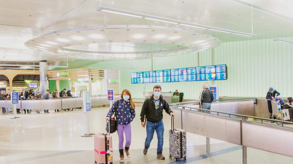 Chen Su, left, and Daniel Flash, wear face masks at Los Angeles International Airport on Jan. 22, 2019, in Los Angeles, to protect against the coronavirus. Travelers arriving from Wuhan, China — epicenter of the coronavirus epidemic — will be screened at 20 ports of entry to the United States, federal officials said on Tuesday, Jan. 28, 2020. 