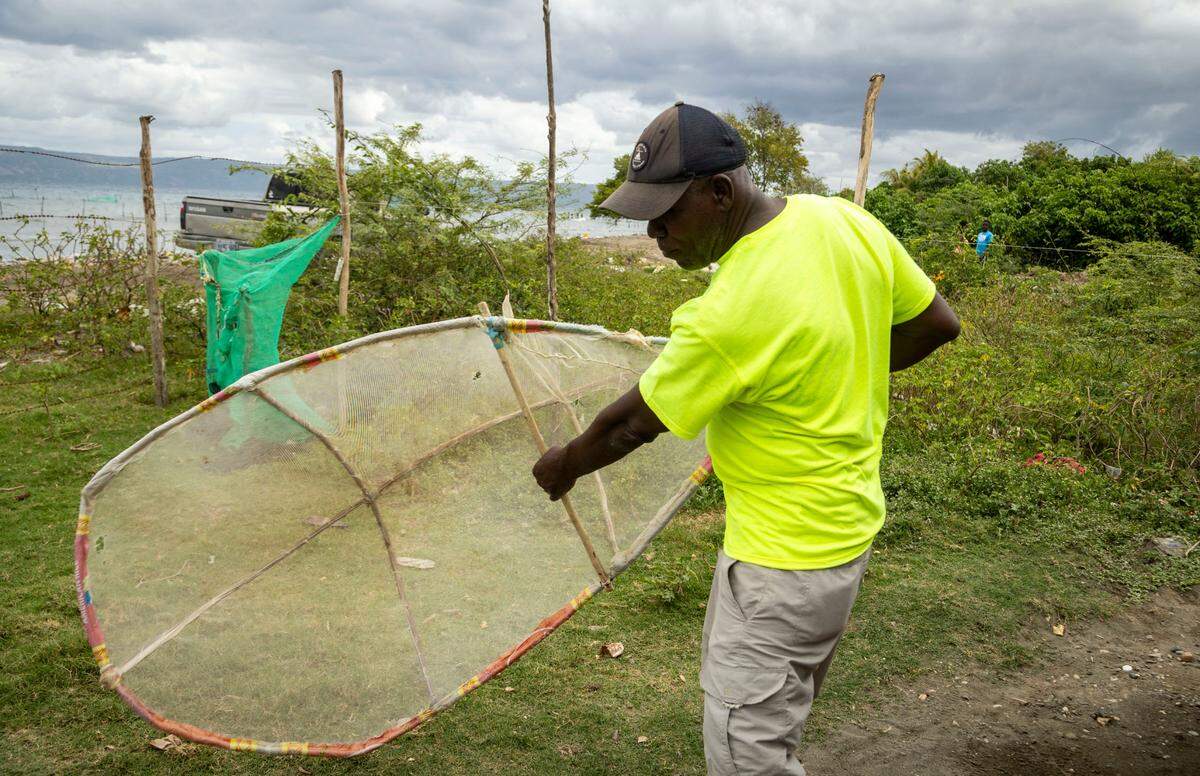 Samuel Tervil demonstrates his technique for harvesting eels in Port-de-Paix, using a homemade net to catch the fish known as zangi in Haitian-Creole.