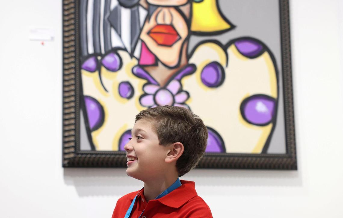 Andreas Valencia, 11, right, greets guests while his artwork hangs in the background during the opening night of VIP for Art Miami on Tuesday, Nov. 29, 2022, at CONTEXT Art Miami. Many of his pieces have already sold. Valencia just turned 11 recently. “I’m glad that people like my art,” said Valencia.