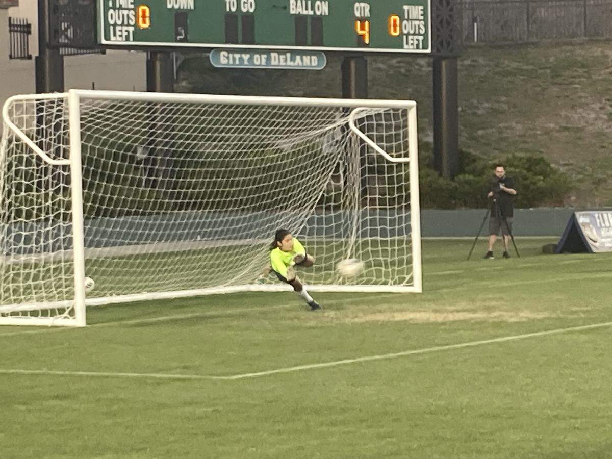 Cypress Bay goalkeeper Alejandra Duran dives to her left to stop a penalty kick during the Class 7A state final against Lake Mary on Wednesday at Spec Martin Stadium in DeLand, Fla.