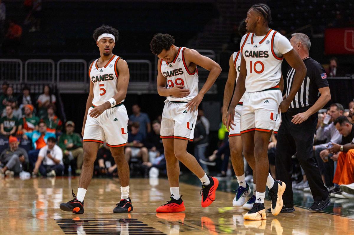 Miami (Fl) Hurricanes guard Divine Ugochukwu (99) holds his side after falling during the first half of an NCAA basketball game against the Florida State Seminoles at Watsco Center on Wednesday, January 8, 2025, in Coral Gables, Fla.