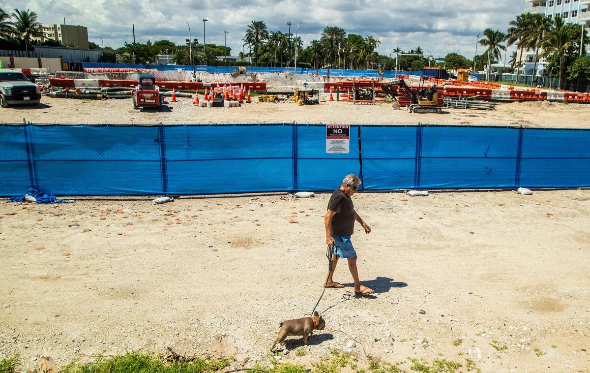 A man walks his dog near the Champlain Towers South property in Surfside, Florida, on Thursday, Sept. 23, 2021.