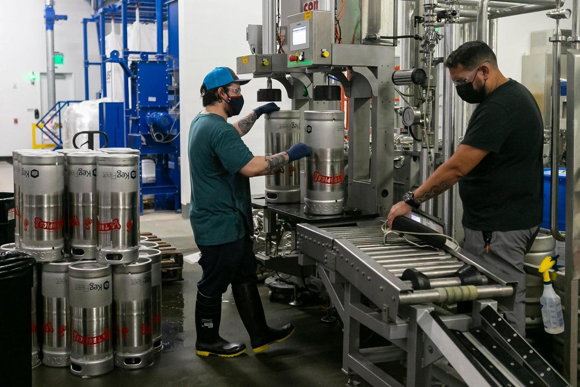 Andres Torrealba, left, and Harold Perez fill kegs with La Tropical’s Nativo Key beer at Cerveceria La Tropical’s brew house in Wynwood on Wednesday, February 17, 2021.