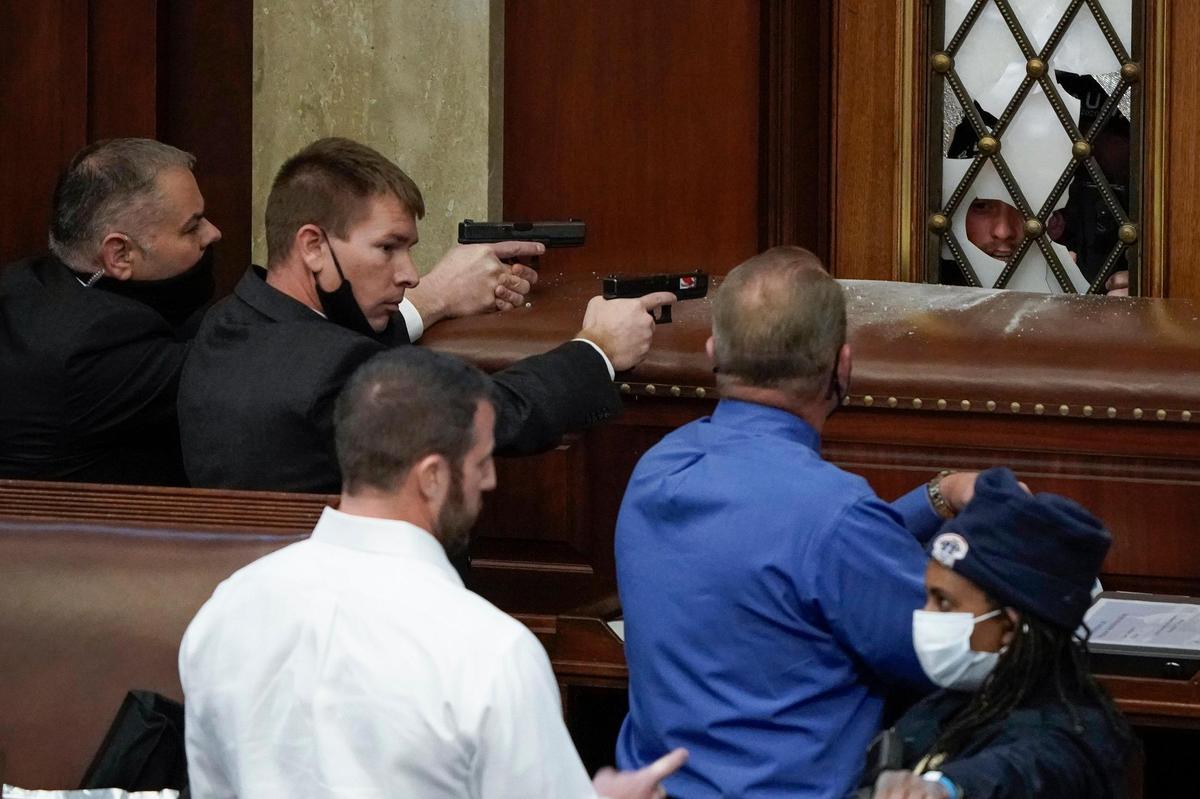 U.S. Capitol Police with guns drawn watch as protesters try to break into the House Chamber at the U.S. Capitol in Washington on Wednesday, Jan. 6, 2021.
