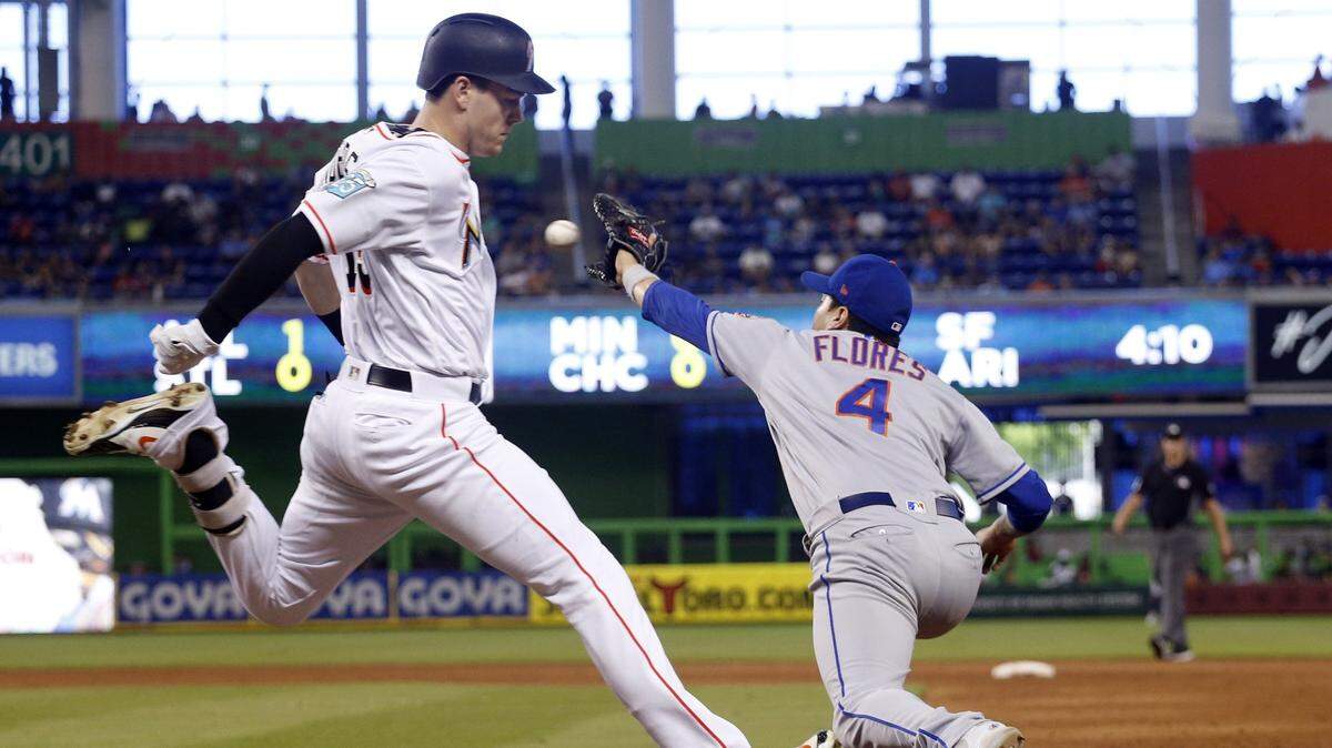 Marlins Brian Anderson touches first base to avoid the out by Mets Wilmer Flores at the bottom of the 6th inning during the Marlins against the Mets game on Sunday, July 1, 2018 at Marlins Park. 