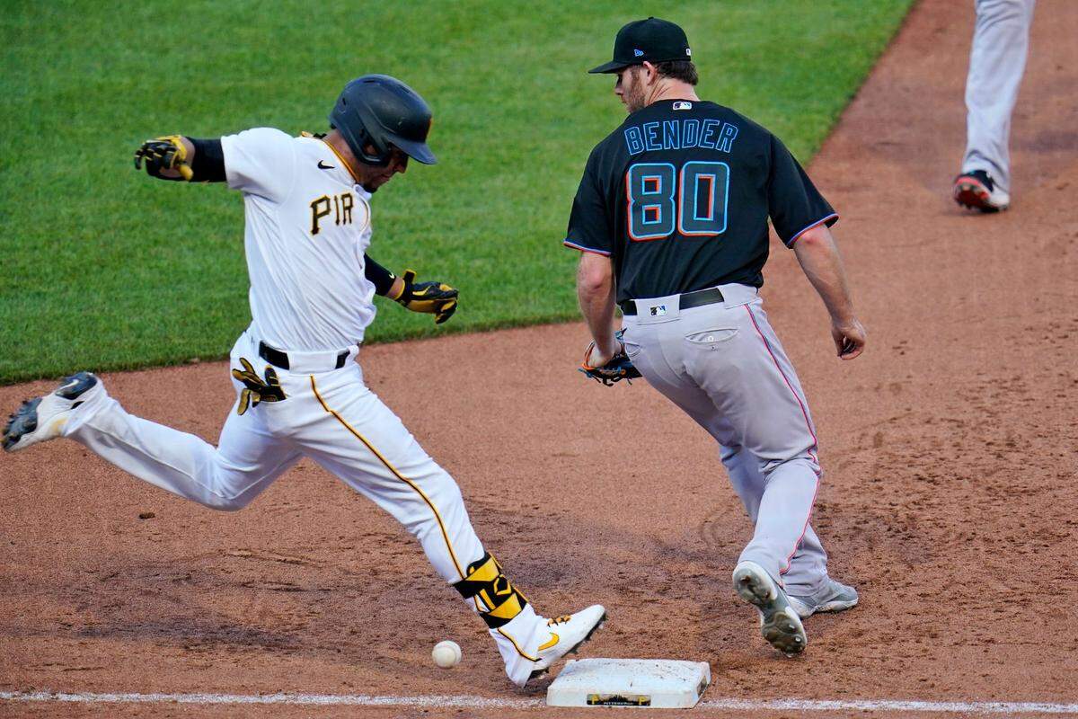 Pittsburgh Pirates’ Michael Perez, left, reaches first base on a fielding error by Miami Marlins relief pitcher Anthony Bender (80) during the eighth inning of a baseball game in Pittsburgh, Saturday, June 5, 2021. A run scored on the play.