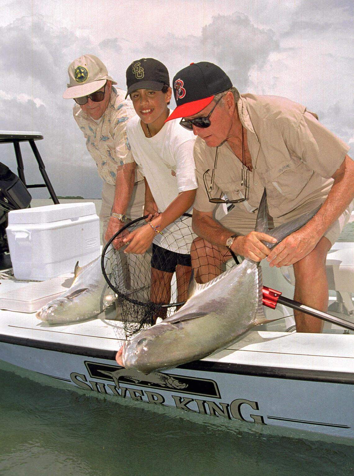 Former President Bush, right, light tackle fishing guide George Hommell, left, and the president’s grandson, Jeb Bush, get ready to release two live permit fish that the president and his grandson caught Tuesday, Aug. 22, 1995 while competing in the George Bush/Cheeca Lodge Bonefish Tournament in the Florida Keys.
