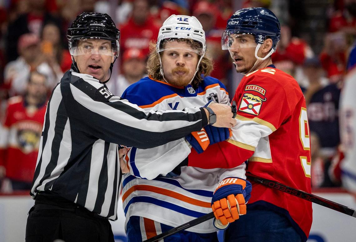 Edmonton Oilers right wing Kasperi Kapanen (42), center is held back by a referee and Florida Panthers left wing Tomas Nosek (92) during the second period of Game 3 in the NHL Stanley Cup Final series at Amerant Bank Arena on Monday, June 9, 2025, in Sunrise, Fla.