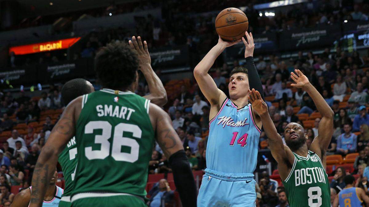 Tyler Herro, del Heat (14), tira al aro ante los jugadores de los Celtics Jaylen Brown (7), Marcus Smart (36) yel 28 de enero en Miami.
