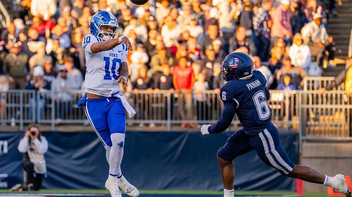 EAST HARTFORD, CONNECTICUT - NOVEMBER 08: Darian Mensah #10 of the Duke Blue Devils throws the ball while being pursued by Bryun Parham #6 of the Connecticut Huskies during the first half of an NCAA football game at Rentschler Field on November 08, 2025 in East Hartford, Connecticut. (Photo by Joe Buglewicz/Getty Images)