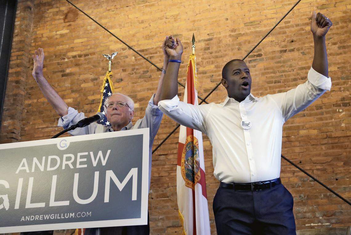 U.S. Sen. Bernie Sanders of Vermont, left, and Democratic gubernatorial hopeful Andrew Gillum hold hands during a campaign rally Friday, Aug. 17, 2018, in Tampa.
