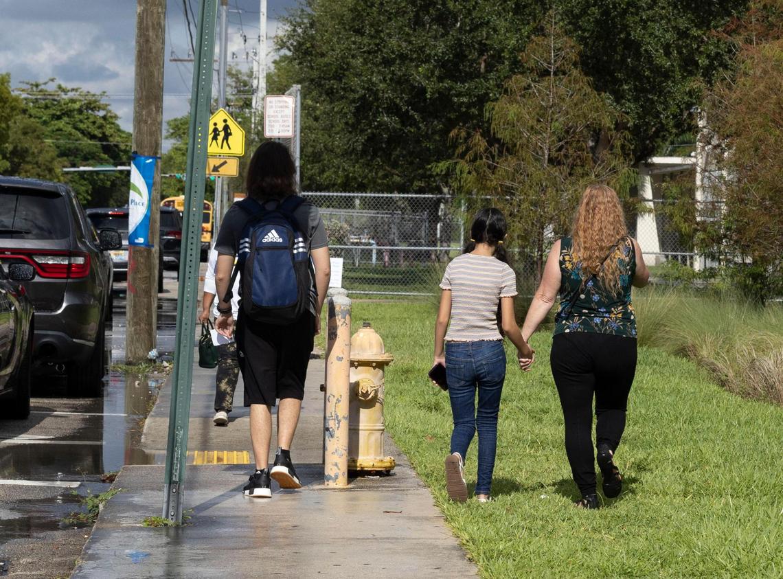 A woman picks up two kids at Palmetto Senior High School on Tuesday morning, Aug. 23, 2022, in Pinecrest, Florida. A student with ‘traumatic injuries’ was airlifted from the school shortly after the school day began due to a possible fall, according to Miami-Dade Fire Rescue. School district officials have not identified the student, nor has Fire Rescue.