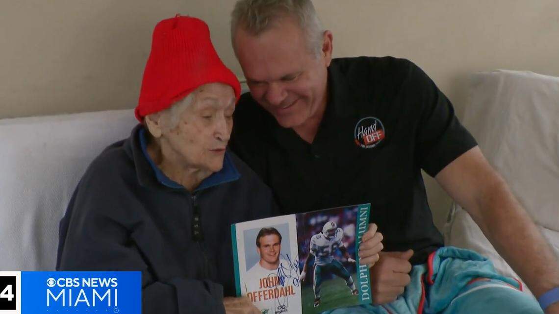 Barbara ‘BJ’ Mundy holds pictures of John Offerdahl during his days with the Miami Dolphins. Mundy is grateful for the meals that Offerdahl and volunteers deliver to her. Barbara ‘BJ’ Mundy holds pictures of John Offerdahl during his days with the Miami Dolphins. Mundy is grateful for the meals that Offerdahl and volunteers deliver to her.