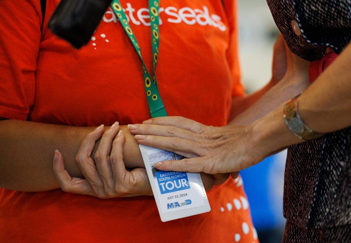 Commissioner Raquel Regalado, right, holds her daughter, Isabela’s hand while she wears the sunflower lanyard during an airport readiness drill with Easterseals South Florida kids to prepare them for experiencing air travel on Tuesday, July 23, 2024, at Miami International Airport. Many of the kids have autism or other disabilities that can make airports stressful, so this tour showed them what it was like.