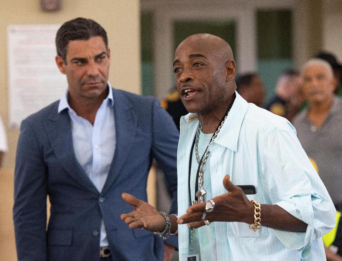 Miami Mayor Francis Suarez, left, listens to a man from Camillus House speak after a press conference announcing a $2 million city donation to Camillus House as part of the “Functional Zero” homeless plan on Friday, Oct. 14, 2022, in Miami.