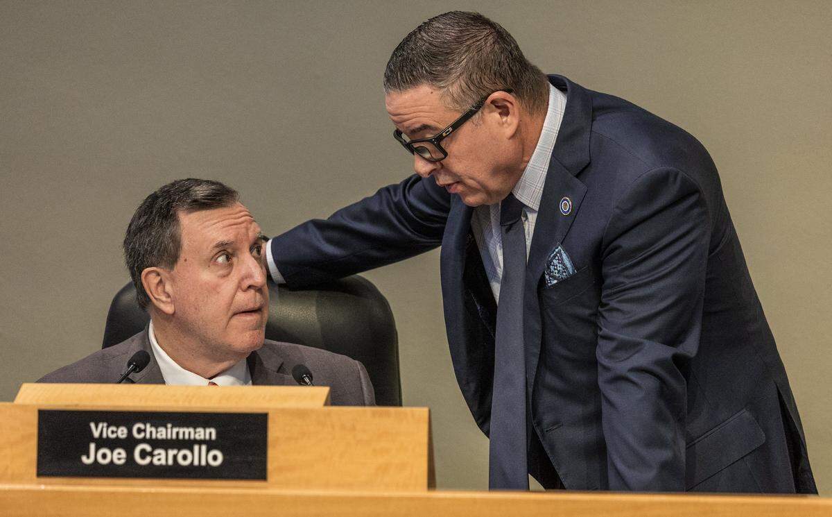 City of Miami Commissioner Joe Carollo (left), talks with City Manager Art Noriega, during a Commission meeting to discuss the proposed sale of the Olympia Theater at the Gusman Center for the Performing Arts' entire building to a public charter school, called Sports Leadership Arts Management, (SLAM), at City Hall, on Thursday September 25, 2025.