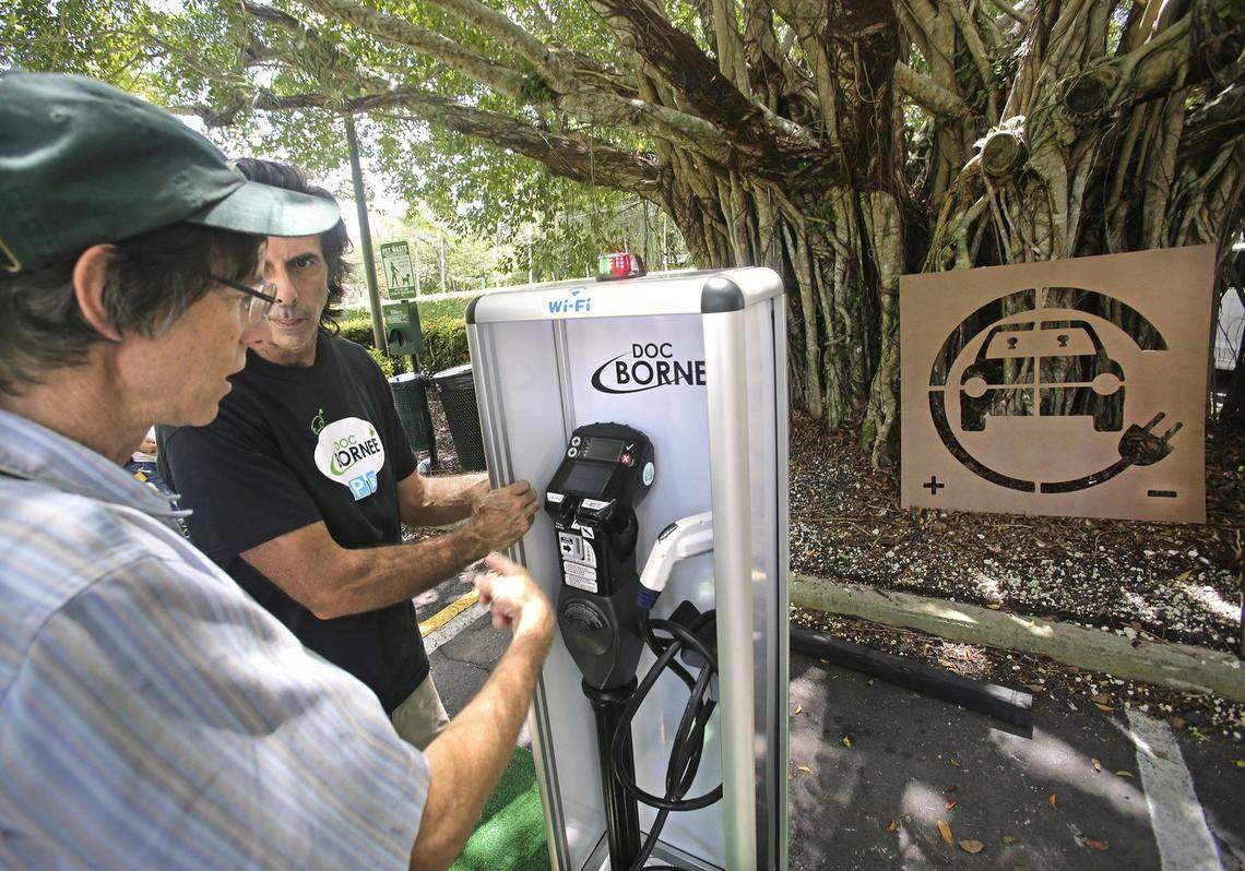 Martin Pednaud, owner/manager of Doc Borne USA, discusses the merits of an electric vehicle charging station with South Miami Mayor Philip Stoddard, left, during the Pinecrest Electric Vehicle Tailgate Event on Saturday, Sept. 19, 2015 at Pinecrest Gardens.