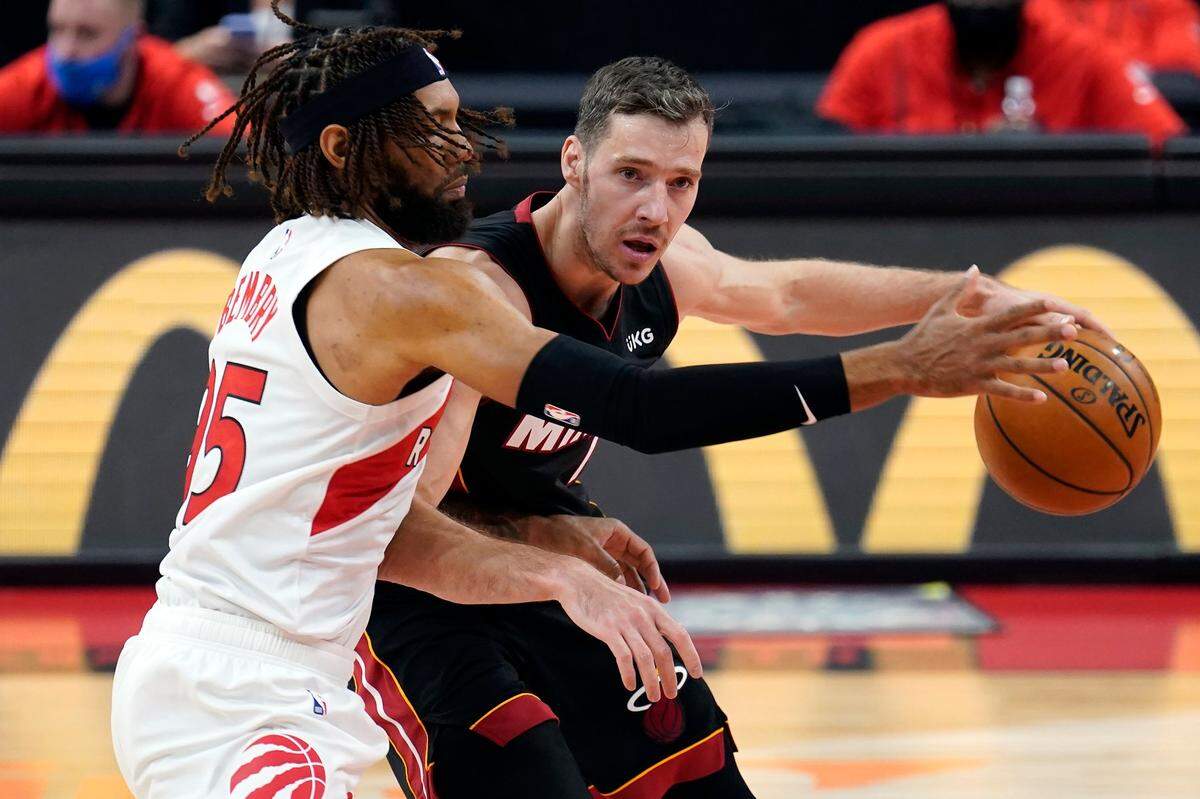 Toronto Raptors forward DeAndre’ Bembry (95) blocks Miami Heat guard Goran Dragic (7) from driving up the floor during the second half of an NBA preseason basketball game Friday, Dec. 18, 2020, in Tampa.