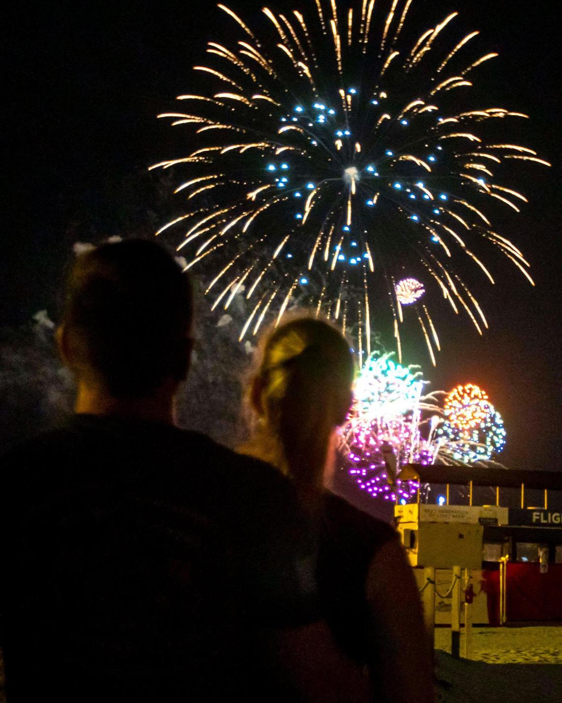 Two people embrace as they watch fireworks explode over the beach near Ocean Drive during the second day of Memorial Day Weekend in Miami Beach, Florida, on Saturday, May 28, 2022.
