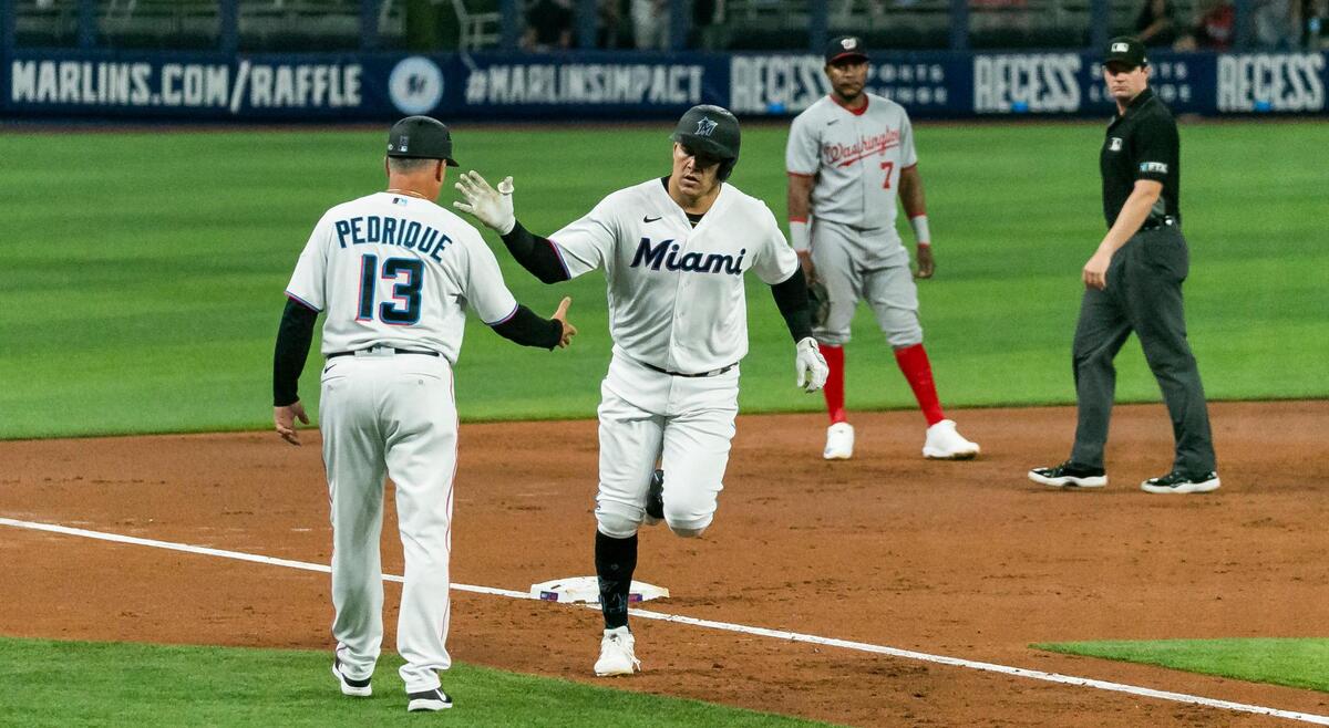 Miami Marlins right fielder Avisail Garcia (24) celebrates with third base coach Al Pedrique (13) after hitting a homer against the Washington Nationals during the second inning of their baseball game at LoanDepot Park on Monday, May 16, 2022, in Miami, Florida.