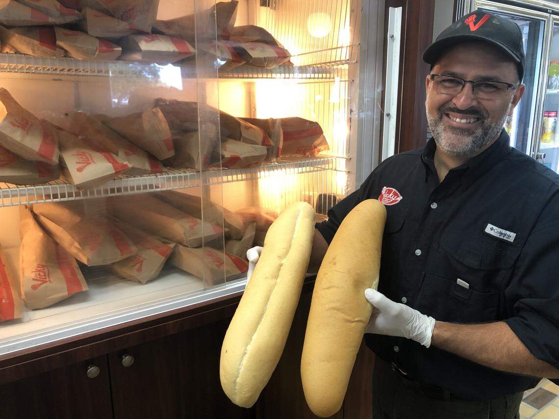Fernando Oramas of Vicky Bakery compares loaves of traditional Cuban bread (left) and a new vegan version.