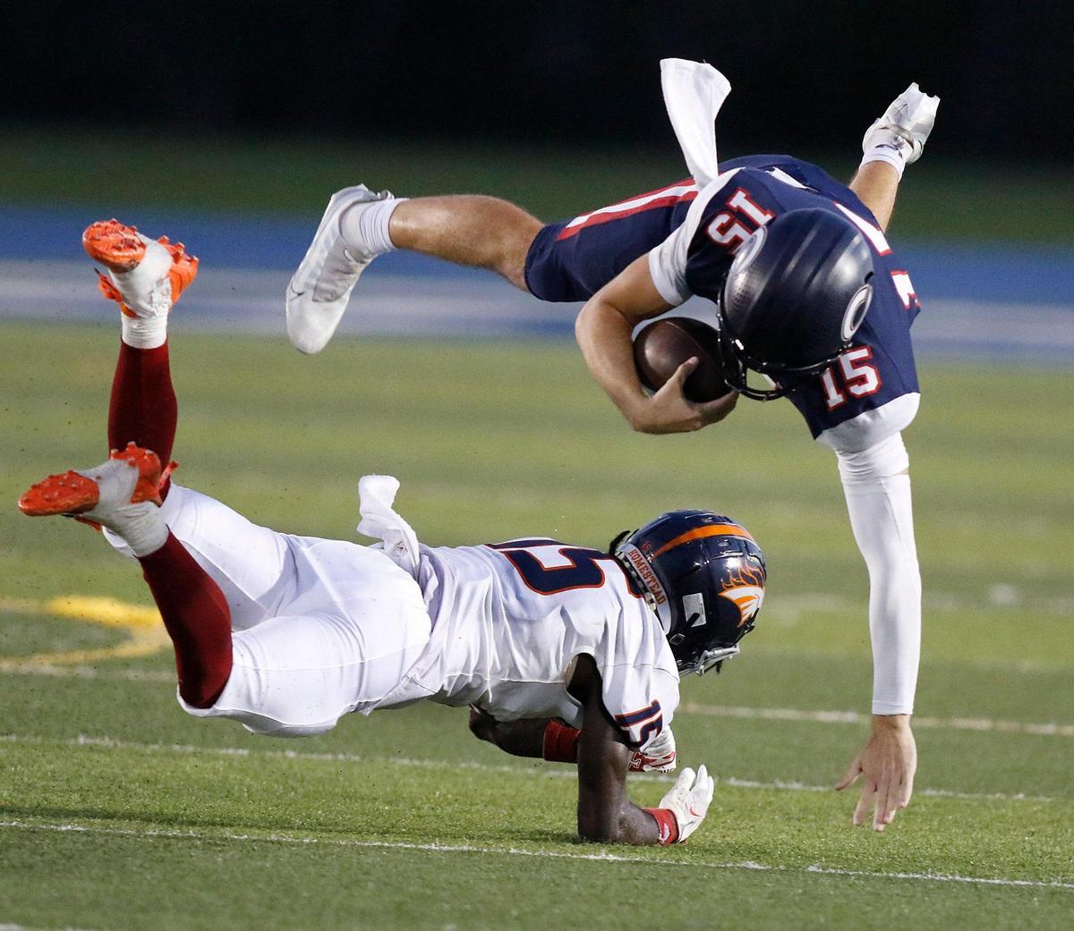 Columbus Explorers quarterback Alberto Mendoza (15) jumps over Homestead Broncos defensive back Semaj Smith (15) during the football game on Saturday, October 07, 2023 at Tropical Park Stadium in Miami. Andrew Uloza / for Miami Herald