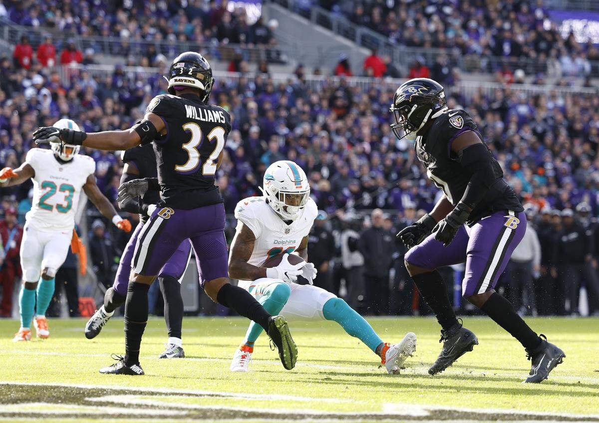 Miami Dolphins wide receiver Cedrick Wilson Jr. (11) catches a pass for a touchdown against the defense of Baltimore Ravens safety Marcus Williams (32) and Ravens linebacker Roquan Smith (0) during first half of an NFL football game at M&T Bank Stadium in Baltimore, Maryland on Sunday, December 31, 2023.