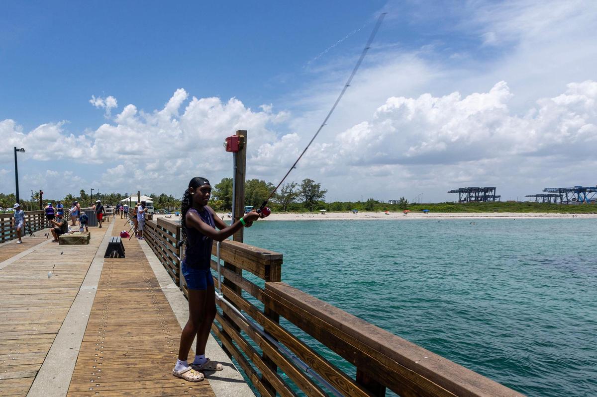 Camper Chenaya Desire casts her bait from the pier during a Root Collectives summer camp field trip.
