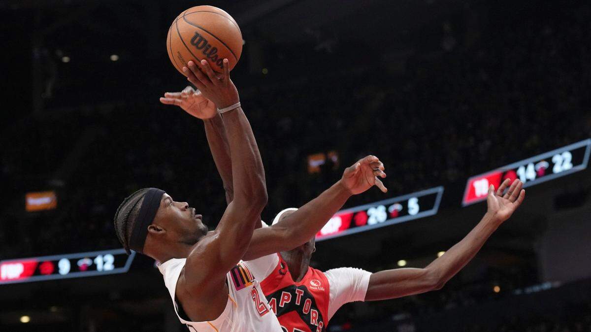 Miami Heat’s Jimmy Butler, left, shoots on Toronto Raptors’ Chris Boucher during the second half of an NBA basketball game in Toronto on Wednesday, Nov. 16, 2022.