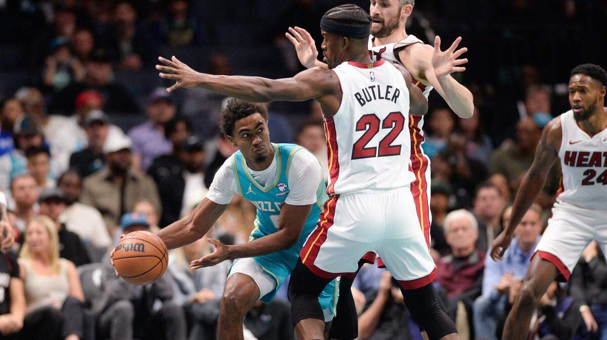 El escolta de los Hornets Theo Maledon (izq.) trata de pasar la pelota ante la marca de Jimmy Butler, del Heat de Miami, en el partido celebrado el 14 de noviembre de 2023 en Charlotte.