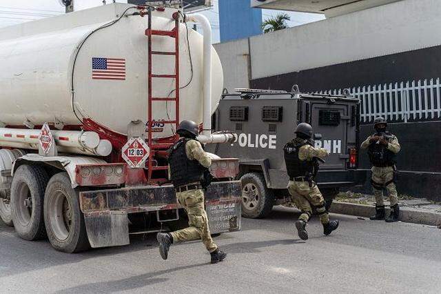 Police officers escort trucks leaving the Varreux terminal after refueling, in a neighborhood occupied by armed gangs, in Port-au-Prince, Haiti, on November 8, 2022. (Photo by Richard Pierrin / AFP) (Photo by RICHARD PIERRIN/AFP via Getty Images)