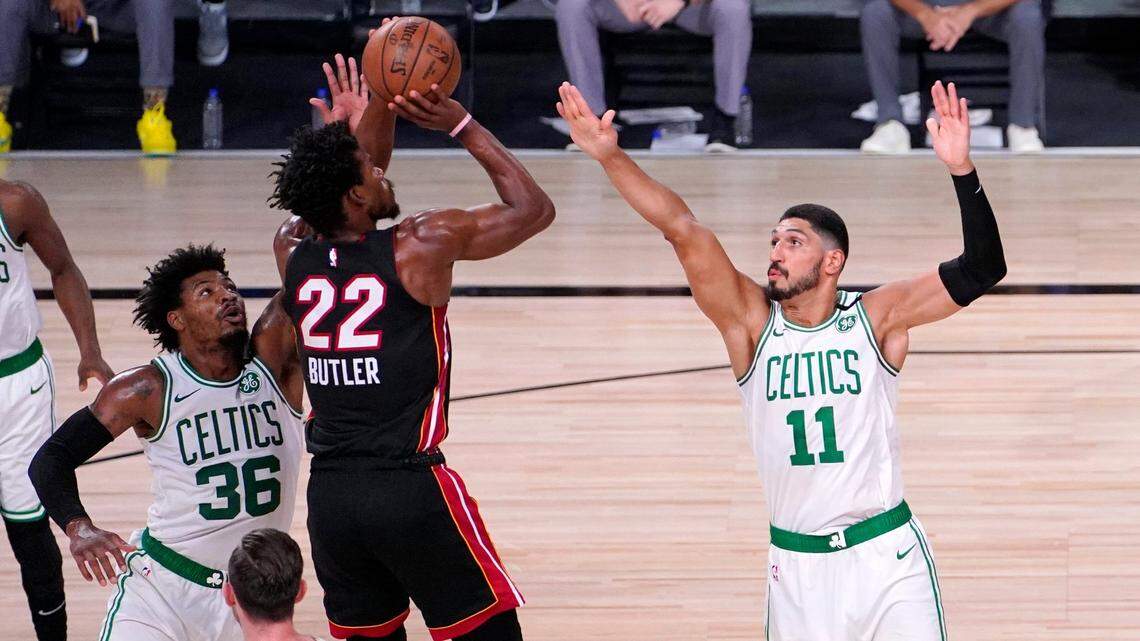 Miami Heat’s Jimmy Butler (22) takes a shot as Boston Celtics’ Enes Kanter (11) and teammate Marcus Smart (36) defend during the first half of an NBA conference final playoff basketball game Sunday, Sept. 27, 2020, in Lake Buena Vista, Fla. (AP Photo/Mark J. Terrill)