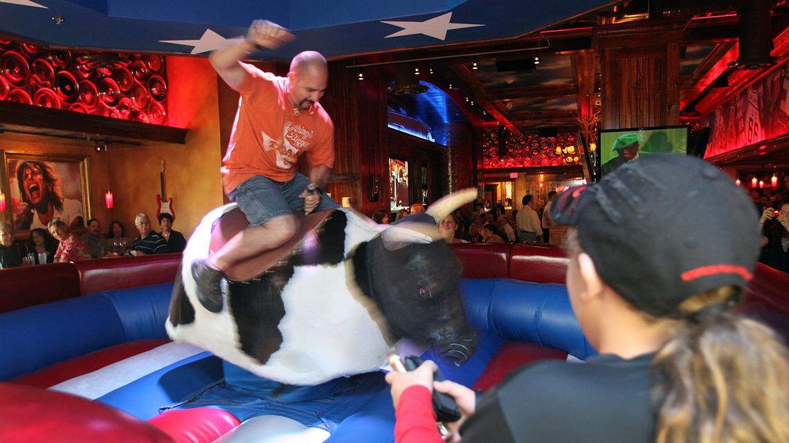 A rider tries to tame the mechanical bull at Cadillac Ranch in Kendall at its opening in 2011.