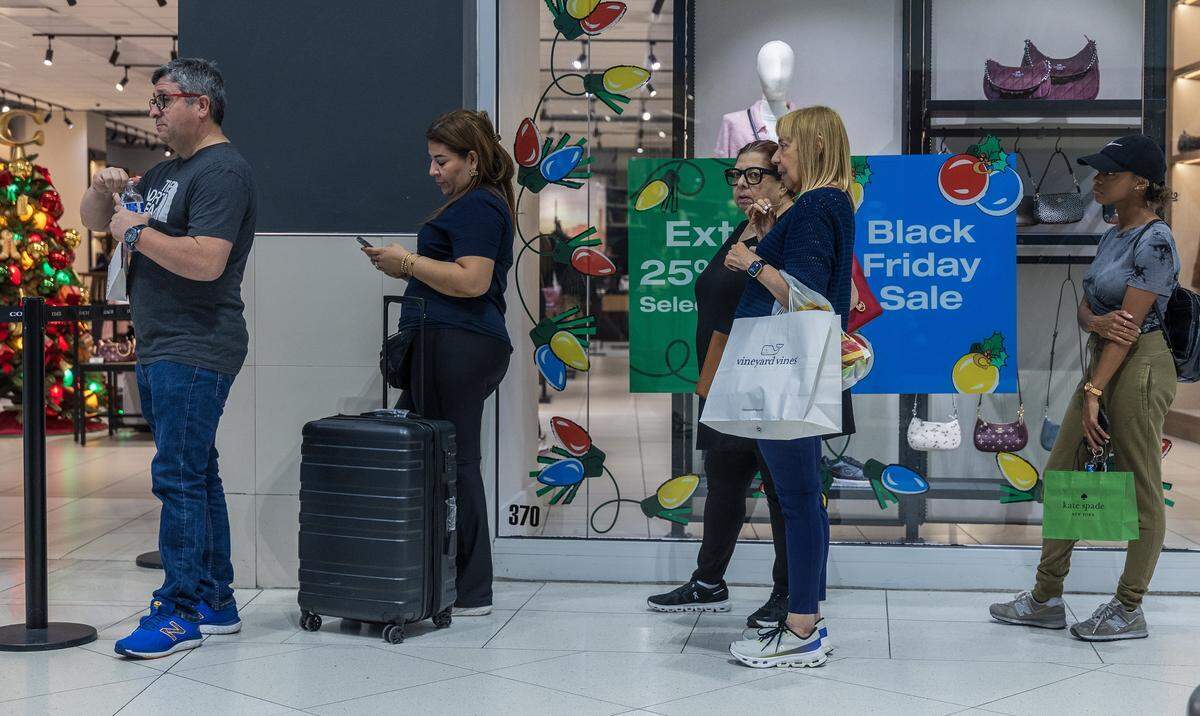 Shoppers line up to enter the Coach store in the Dolphin Mall on Friday, Nov. 21, 2025.