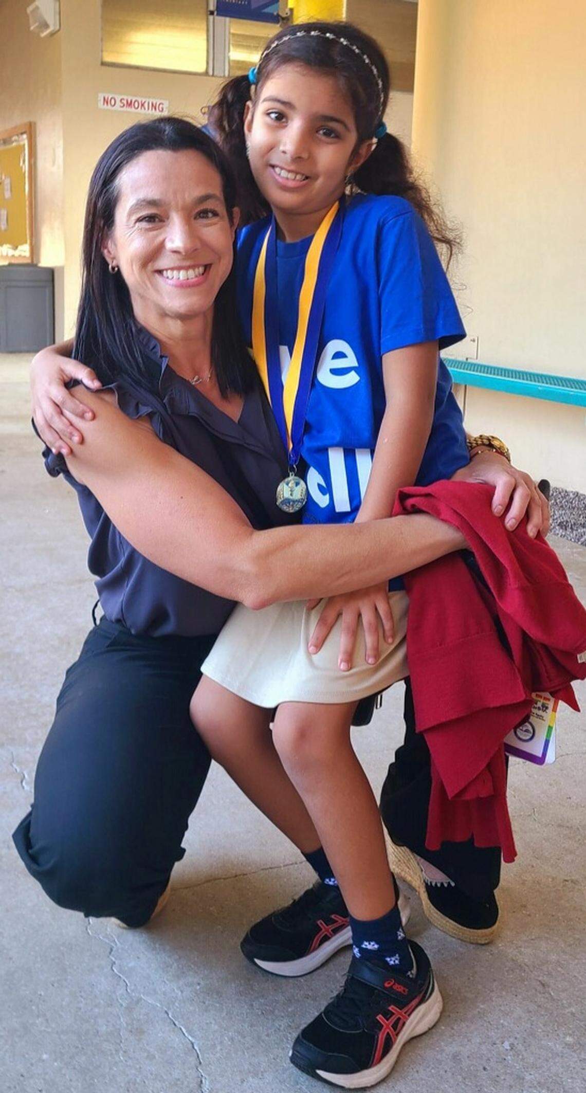 Judie ElAttar with her principal, Lucy Amengual, after winning the school’s spelling bee.