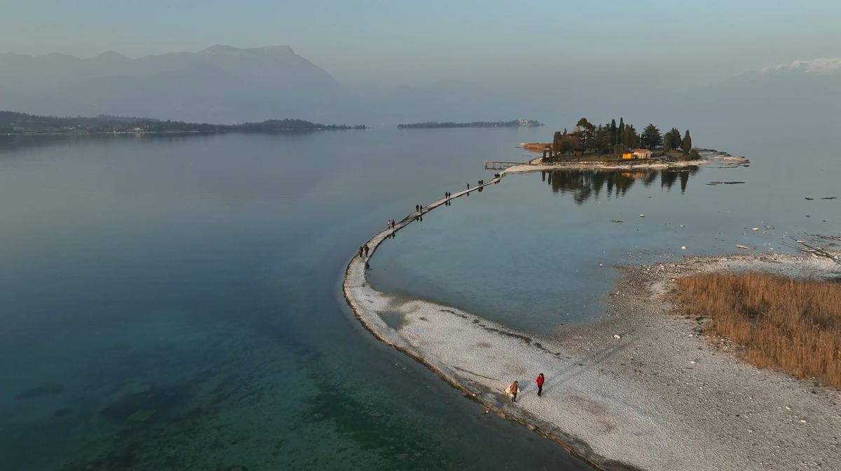Drone footage shows people walking along the exposed pathway.