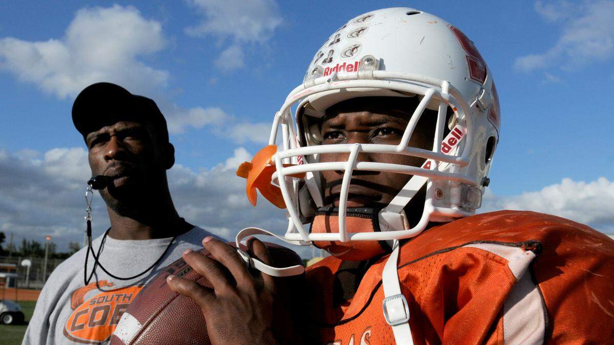 Amos “A.J.” Leggett, right, works with head coach Lamont Green, left, at South Miami High School Cobra’s football practice, Tuesday, November 22, 2011.