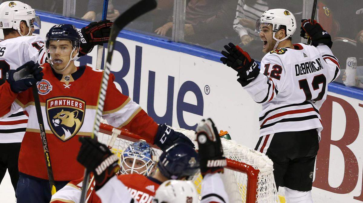 Chicago Blackhawks left wing Alex DeBrincat (12) celebrates his game-tying goal with seconds remaining in regulation against the Florida Panthers in an NHL hockey game Saturday, Nov. 24, 2018, in Sunrise, Fla. The Blackhawks won 5-4 in overtime. (AP Photo/Joe Skipper)